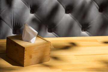A napkin holder stands on a wooden table in a cafe. Morning coffee for breakfast.