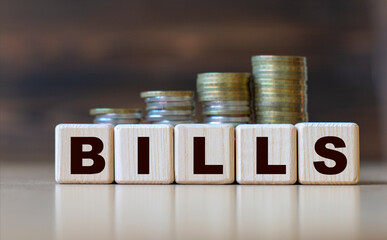 BILLS word on diced on a beautiful dark background with coins