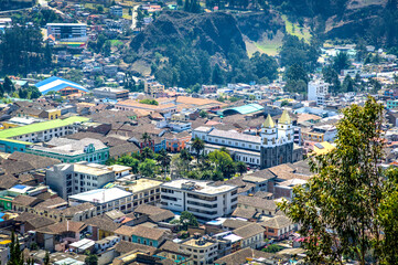 View of downtown Guaranda, with it's cathedral and central buildings, surrounded by the Andes mountains, on a sunny morning.