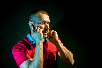 a man is listening to music on wireless headphones on a dark  background