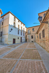 Vertical view of the crossing of the Jewish quarter of the city of Toledo with the Casa del Judio centuries old jew's house ruins archaeological site on the left, Castilla la Mancha, Spain