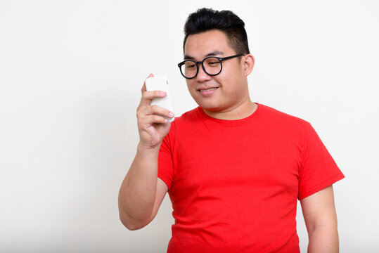 Portrait Of Happy Young Overweight Asian Man Using Phone