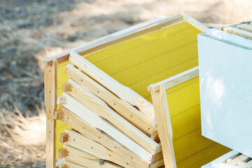 Melting of wax plates. Man work on a new frame with a wax candle for the apiary. Flowers in the...