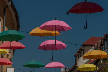 Fototapeta na wymiar Color umbrellas with blue background sky over street in VIllach city