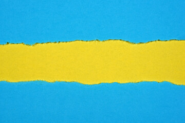 Obraz premium Ripped in blue paper on yellow background