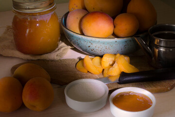 Apricot jam with fresh apricots on the cutting board