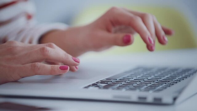 Close up of young female hipster hands working online on latop in bright work space. Remote work concept