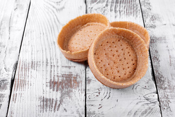 Empty baked shortbread tartlets ready to be filled in with a dessert. Base for mini tarts
