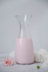 bottle of pink milk and flowers on the white background.