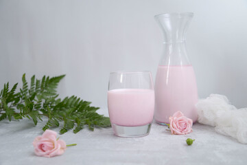 pink  milk in the glass on the white background.