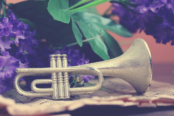 Trumpet on musical paper and purple flowers, vintage