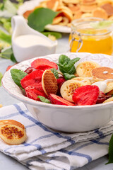 Porridge of tiny pancakes with berries. Trendy food.