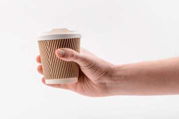 Hand holding a corrugated paper cup on white background