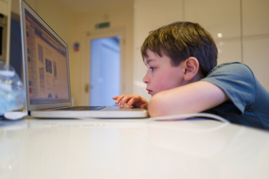 Boy homeschooling at laptop