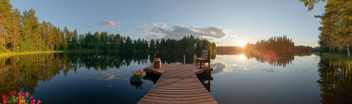 Sun is setting on Finnish lake (panorama)