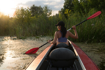 
the girl floats on a kayak on the river.