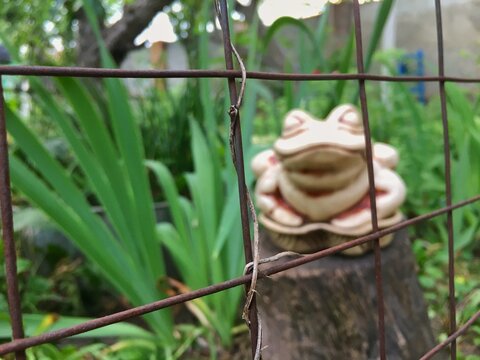 Figurine Of A Toad Standing On A Tree Stump