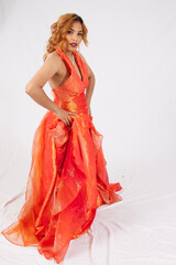 Lovely Hispanic woman in a flowing orange dress