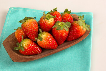 Red fresh strawberry in a bowl on white background.