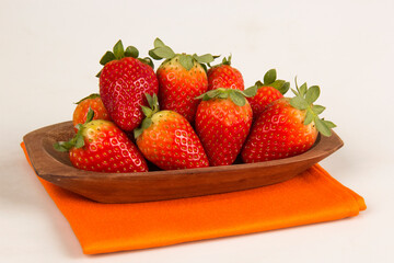 Red fresh strawberry in a bowl on white background.