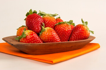 Red fresh strawberry in a bowl on white background.