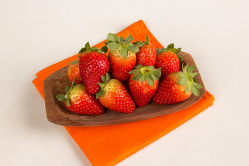 Red fresh strawberry in a bowl on white background.