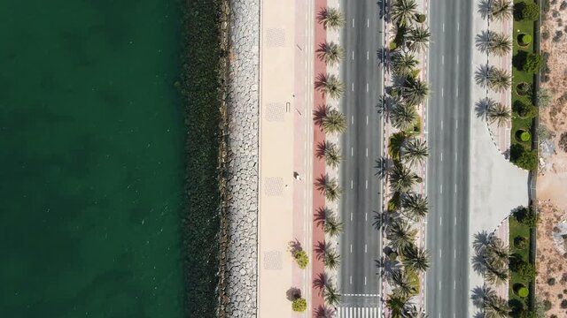 Coastal road with palm trees and running track in Marjan Island in Ras al Khaimah emirate of UAE