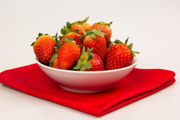 Red fresh strawberry in a bowl on white background.
