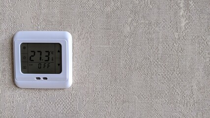 indoor digital thermometer on wall showing temperature in room and that individual heating is off 