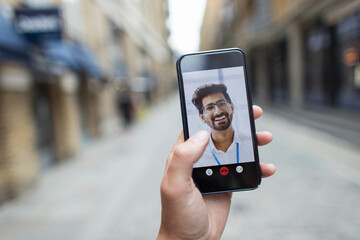 POV Businessmen video conferencing on smart phone screen