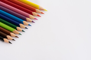 Colored sharpened pencils at the top left on a white sheet of paper