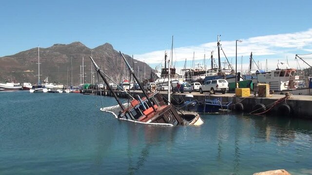Summer day video of Hout Bay harbour and shipwreck in Cape Town, South Africa