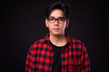 Fototapeta premium Young handsome Asian hipster man with eyeglasses