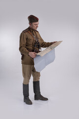 Male actor in the uniform of a Soviet Army officer during World War II with a map of the area in...