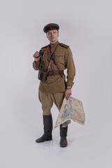 Male actor in the uniform of a Soviet Army officer during World War II with a map of the area in...