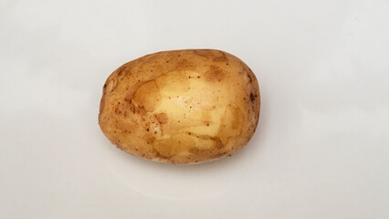 Fototapeta premium One tasty raw yellow potato isolated on white background. Health, food. The new harvest. Raw potato. Space for text.