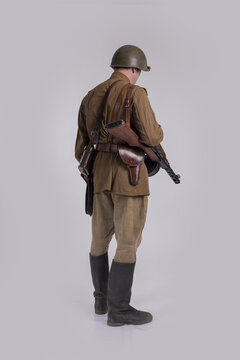 Male actor in the uniform of an officer and a helmet of the Soviet Army during World War II with a rifle in his hands
