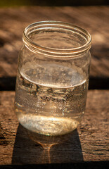 water in a glass jar in the evening light
