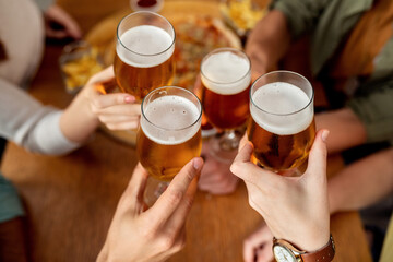 Close-up of friends toasting with beer.