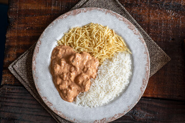 Chicken stroganoff with rice and french fries.