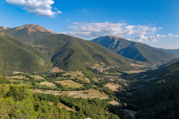Large valley with farms, forests and mountains, with the Commune of Sant'Anatolia of Narco in the center, Umbria region, province of Perugia, Italy