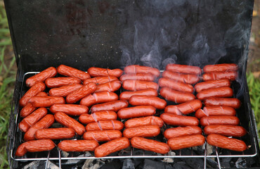 Little sausages roast on the mangale.