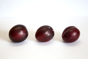 Three plums on a white background.