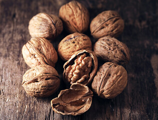 Walnuts in a basket on a wooden table.