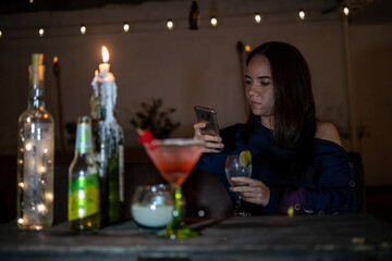 Young woman text messaging in a bar