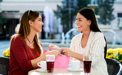 Two women relaxing after shopping in a cafe. Consumerism, lifestyle concept