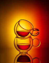 Two glass cup of tea on yellow and red background. Creative concept of tea.