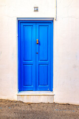 Puerta Azul con la pared blanca en barrio de Conil de Frontera