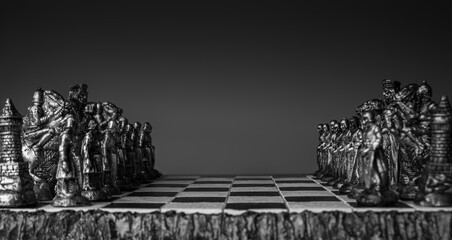 stylized chess pieces on a board with black background, selective focus