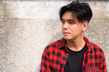 Fototapeta premium Young handsome Asian hipster man in the streets outdoors